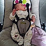 baby, infant, onesie, baby_seat, blanket, soft_toy, cushion, face, person, child, indoors, comfort, cute, newborn, sleepwear, resting, small_hands, footwear, strap, looking