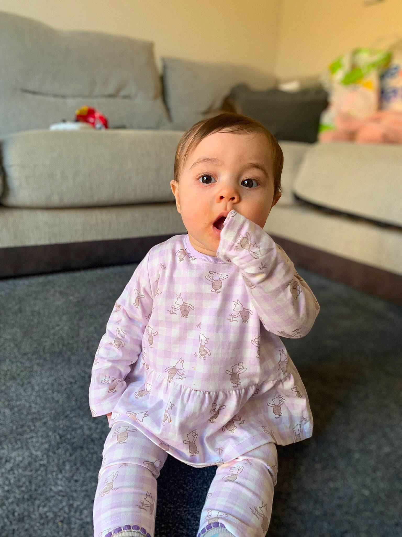 Isla-mae joined the competition — help win amazing prizes! baby, baby_toddler_clothing, cheek, child, comfort, couch, eye, face, floor, flooring, hair, happy, hardwood, head, lip, person, sitting, skin, sleeve, surprise