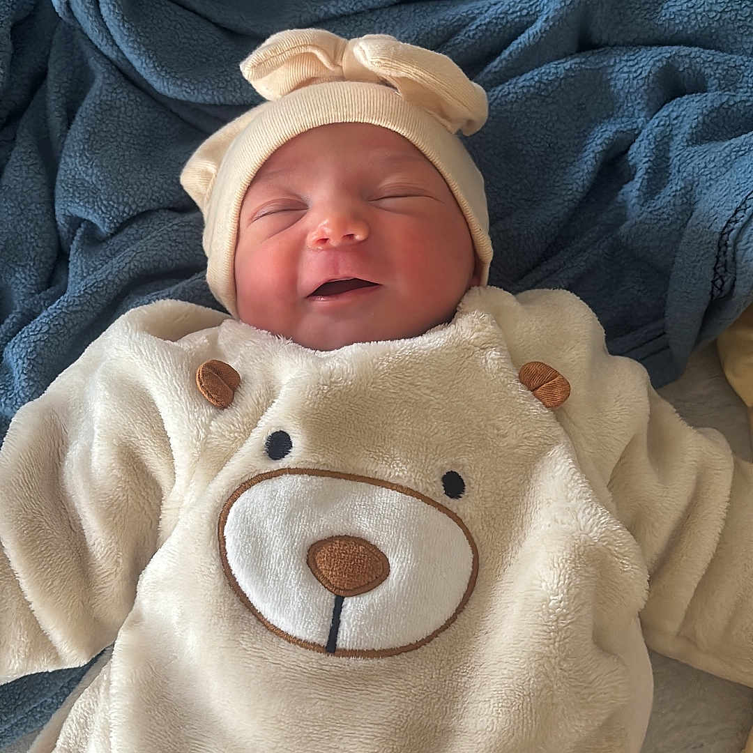 Ahezya participe au concours pour gagner de l'argent avec cette photo : adorable, baby, bear_outfit, blanket, child, clothing, cozy, cute, face, hat, headwear, indoors, infant, newborn, portrait, resting, sleeping, smiling, soft_texture, warm