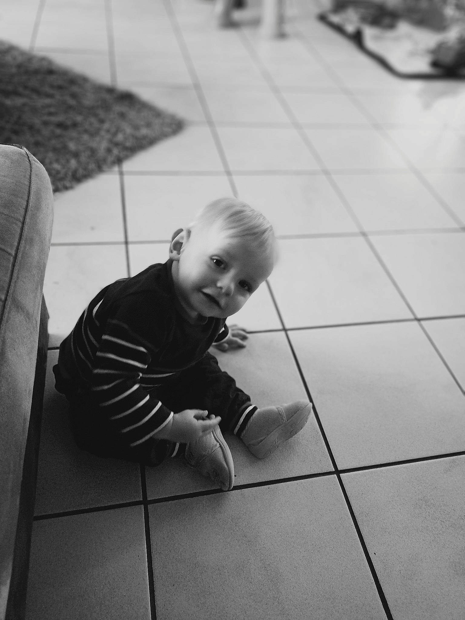 Evann a rejoint le concours — aidez-le/la à gagner de superbes lots ! ankle, baby, baby_toddler_clothing, black, black_and_white, child, floor, flooring, foot, human, human_body, person, tile, tile_flooring, toddler