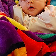 Haisley is registered to the contest to win money with this photo: baby, sleeping, blanket, colorful, infant, face, cozy, soft, patterned_clothing, child, resting, peaceful, cute, indoors, portrait, head, warm, comfort, newborn, zipped_outfit