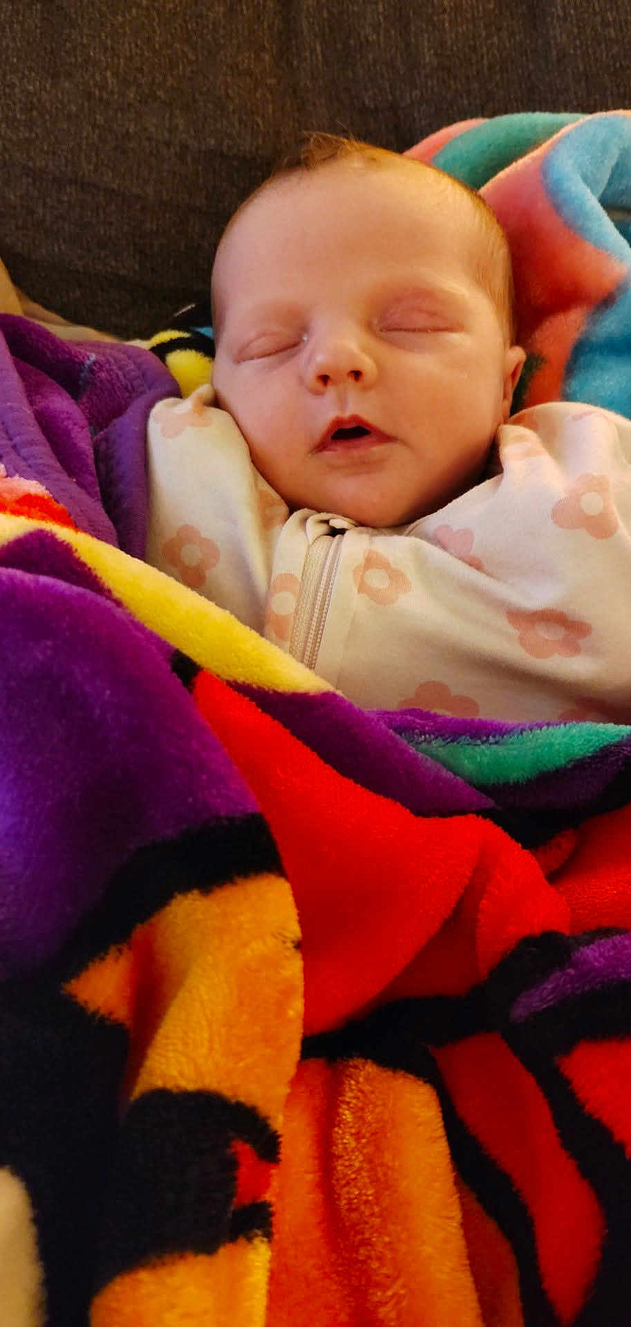 Haisley is registered to the contest to win money with this photo: baby, sleeping, blanket, colorful, infant, face, cozy, soft, patterned_clothing, child, resting, peaceful, cute, indoors, portrait, head, warm, comfort, newborn, zipped_outfit