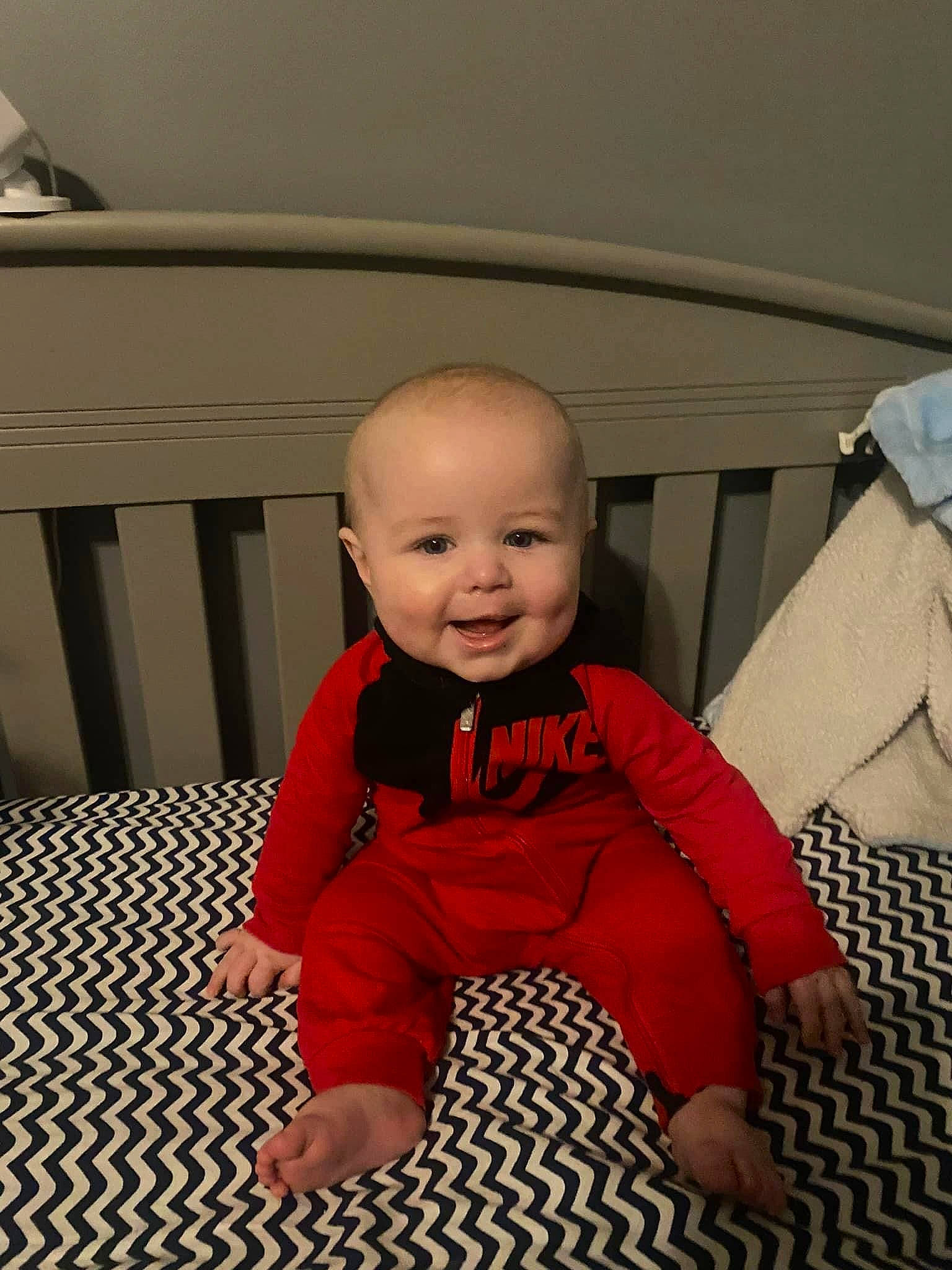 Austin is registered to the contest to win money with this photo: baby, baby_toddler_clothing, carmine, cheek, child, comfort, floor, flooring, foot, fun, happy, hardwood, joy, person, room, sitting, sleeve, smile, sock, t_shirt