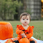 Charlotte is registered to the contest to win money with this photo: baby, child, pumpkin, pumpkins, autumn, fall, orange, outdoor, grass, leaves, harvest, costume, romper, sitting, portrait, face, eyes, infant, blanket, photography