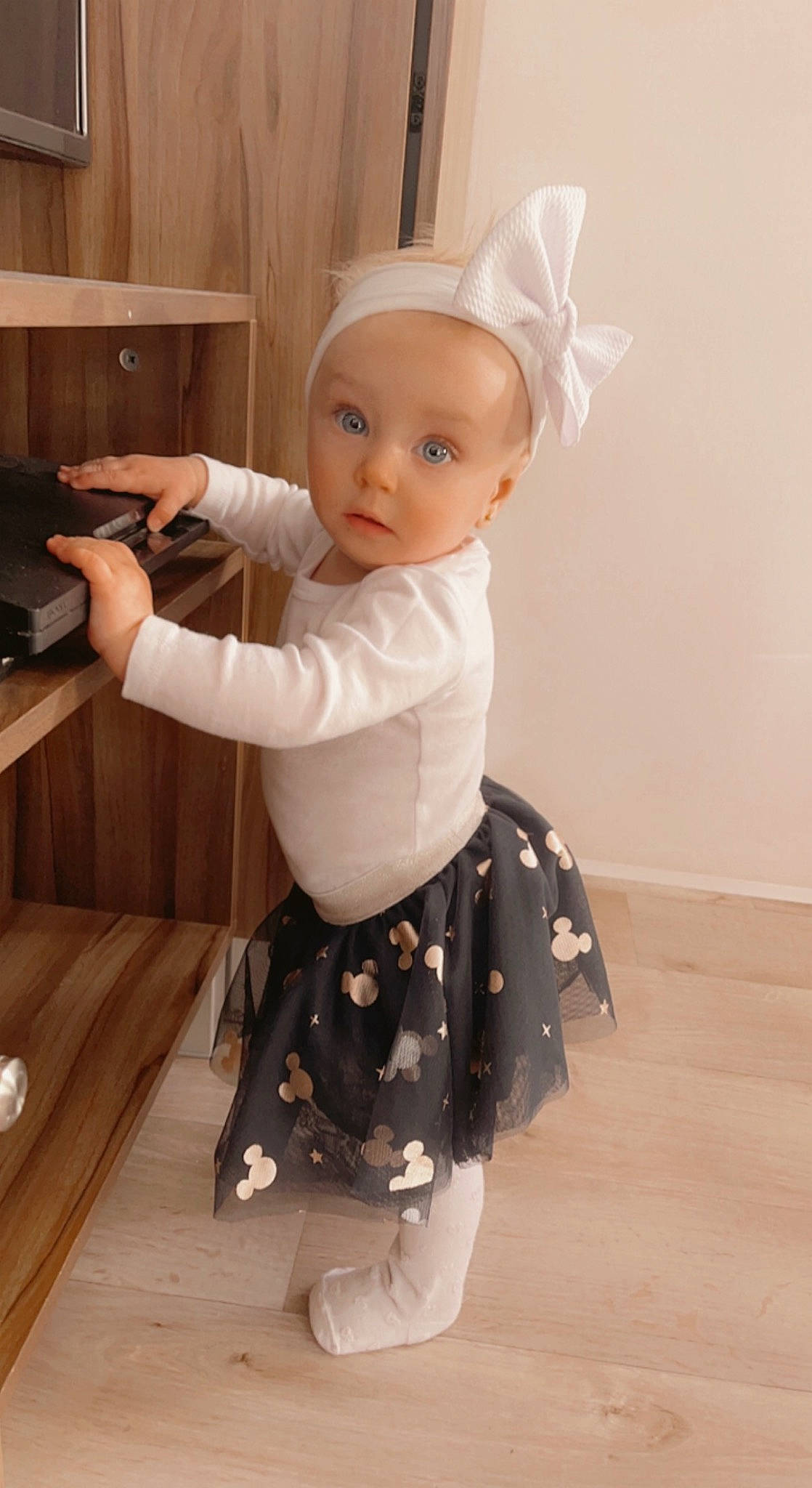 Beverly a rejoint le concours — aidez-le/la à gagner de superbes lots ! arm, baby, baby_toddler_clothing, child, costume, day_dress, drawer, embellishment, fashion_accessory, flooring, formal_wear, hardwood, human_body, one_piece_garment, pattern, person, sleeve, standing, surprise, toddler