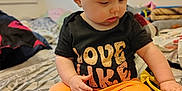 Kinleigh is registered to the contest to win money with this photo: baby, child, infant, headband, orange_shorts, black_shirt, bed, blanket, indoor, person, cute, sitting, footwear, skin, hair, hand, face, clothing, room, window