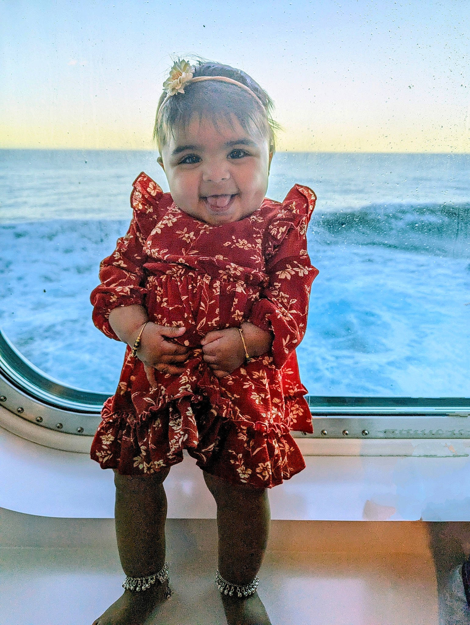 Ariya is registered to the contest to win money with this photo: baby_toddler_clothing, clothing, dress, face, fun, hair, happy, head, human_body, iris, leg, person, shoulder, skin, sky, sleeve, smile, standing, summer, toddler