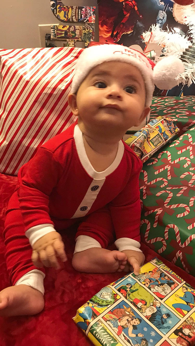 Cassius is registered to the contest to win money with this photo: child, christmas, christmas_eve, event, fictional_character, holiday, interior_design, person, textile, toddler