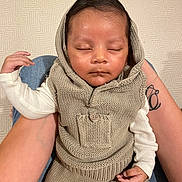 Kemal a rejoint le concours — aidez-le/la à gagner de superbes lots ! baby, sleeping, knitwear, hood, infant, person, tattoo, arm, hand, lap, texture, beige, clothing, resting, peaceful, portrait, indoors, closeup, soft, newborn
