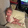 Aspen joined the competition — help win amazing prizes! baby, infant, couch, pillow, socks, clothing, face, person, indoor, living_room, furniture, gaming_chair, computer_monitor, box, blanket, curious, child, relaxed, home, casual
