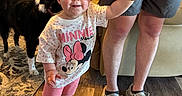 Aspen joined the competition — help win amazing prizes! toddler, child, minnie_mouse, shirt, shorts, sneakers, hand_holding, adult, dog, living_room, carpet, couch, wood_floor, person, smile, indoor, furniture, family, pet, home