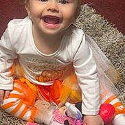 Mercy is registered to the contest to win money with this photo: autumn_colors, baby, bright, carpet, child, cute, festive, fun, happy, headband, indoor, minnie_mouse, orange_bow, playtime, sitting, smiling, striped_leggings, toddler, toy, white_shirt