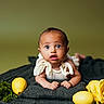 baby, infant, child, face, eyes, blanket, lemons, yellow_rose, flower, green_background, cute, portrait, curious_expression, hands, skin, lying_down, soft_lighting, indoor, colorful, still_life