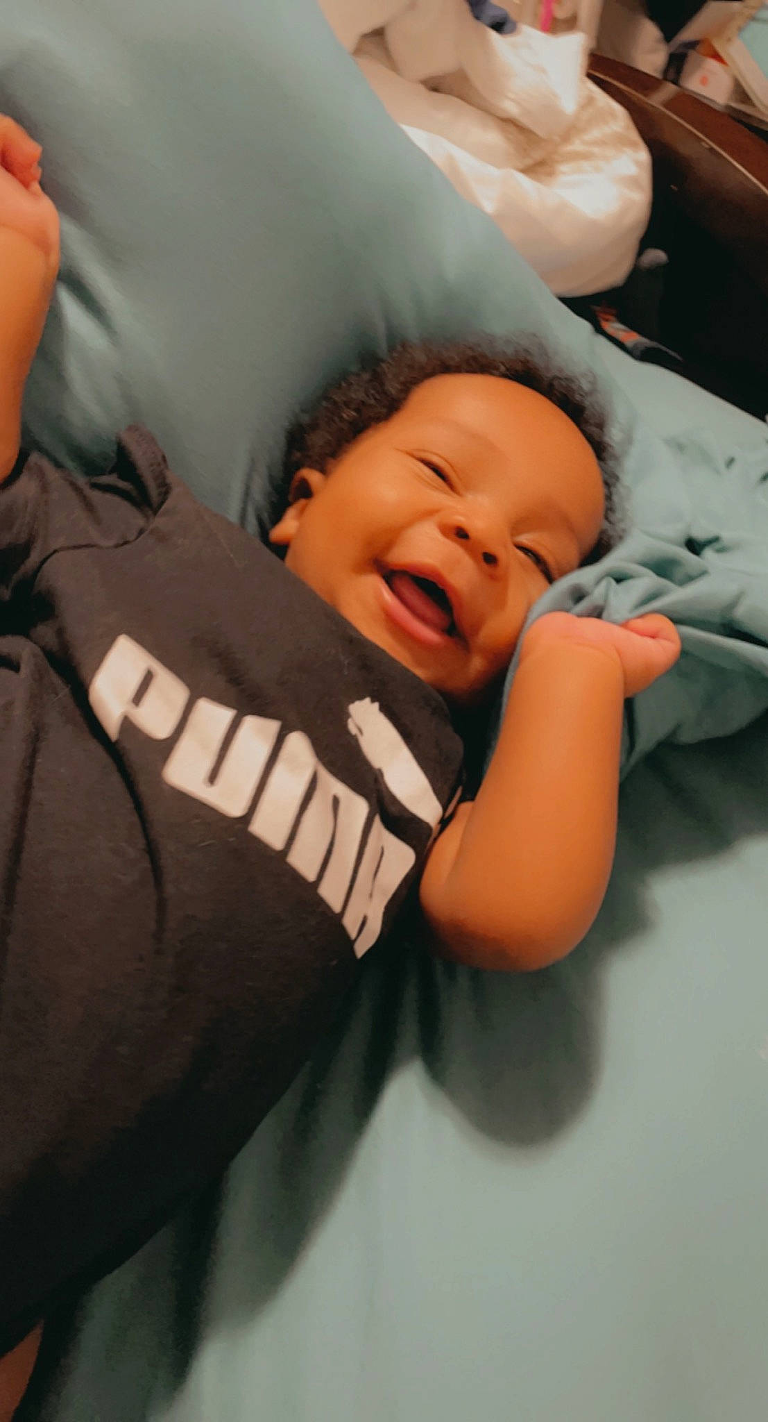 Jamal is registered to the contest to win money with this photo: baby, baby_products, baby_toddler_clothing, beanie, cap, cheek, child, comfort, flash_photography, fun, happy, laugh, mouth, person, personal_protective_equipment, room, sitting, sleeve, smile, t_shirt