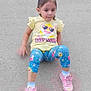 child, toddler, baby_shark, yellow_shirt, blue_pants, pink_shoes, concrete, outdoor, sitting, cute, casual_clothing, young_girl, small_child, playful, fashion, footwear, person, daylight, expression, casual