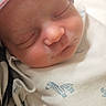 newborn, baby, sleeping, infant, blanket, striped_hat, zebra_print, closeup, face, cozy, hospital, peaceful, cute, soft_light, portrait, child, resting, wrapped, skin, adorable