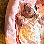 baby, infant, pink_blanket, headband, flower, floral_dress, cute, cozy, portrait, newborn, child, soft_fabric, indoors, resting, lying_down, small_hands, curious, person, toddler, blanket