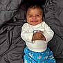 Frankie joined the competition — help win amazing prizes! baby, smiling, infant, child, clothing, shorts, shirt, blanket, fabric, happy, cute, person, lying_down, toddler, pattern, blue, gray, face, skin, indoors