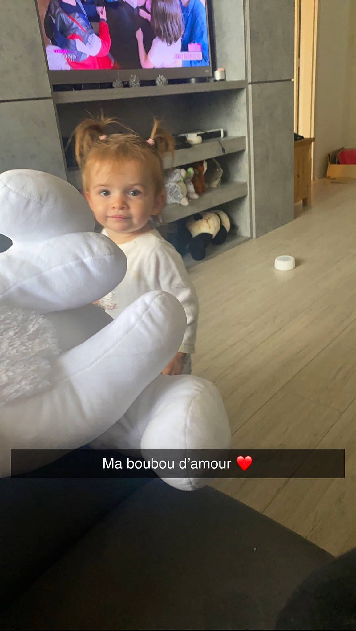 Clara a rejoint le concours — aidez-le/la à gagner de superbes lots ! child, comfort, flash_photography, floor, flooring, fun, furniture, hand, happy, hardwood, home_appliance, leg, living_room, person, room, shelf, sitting, television, television_set, toddler