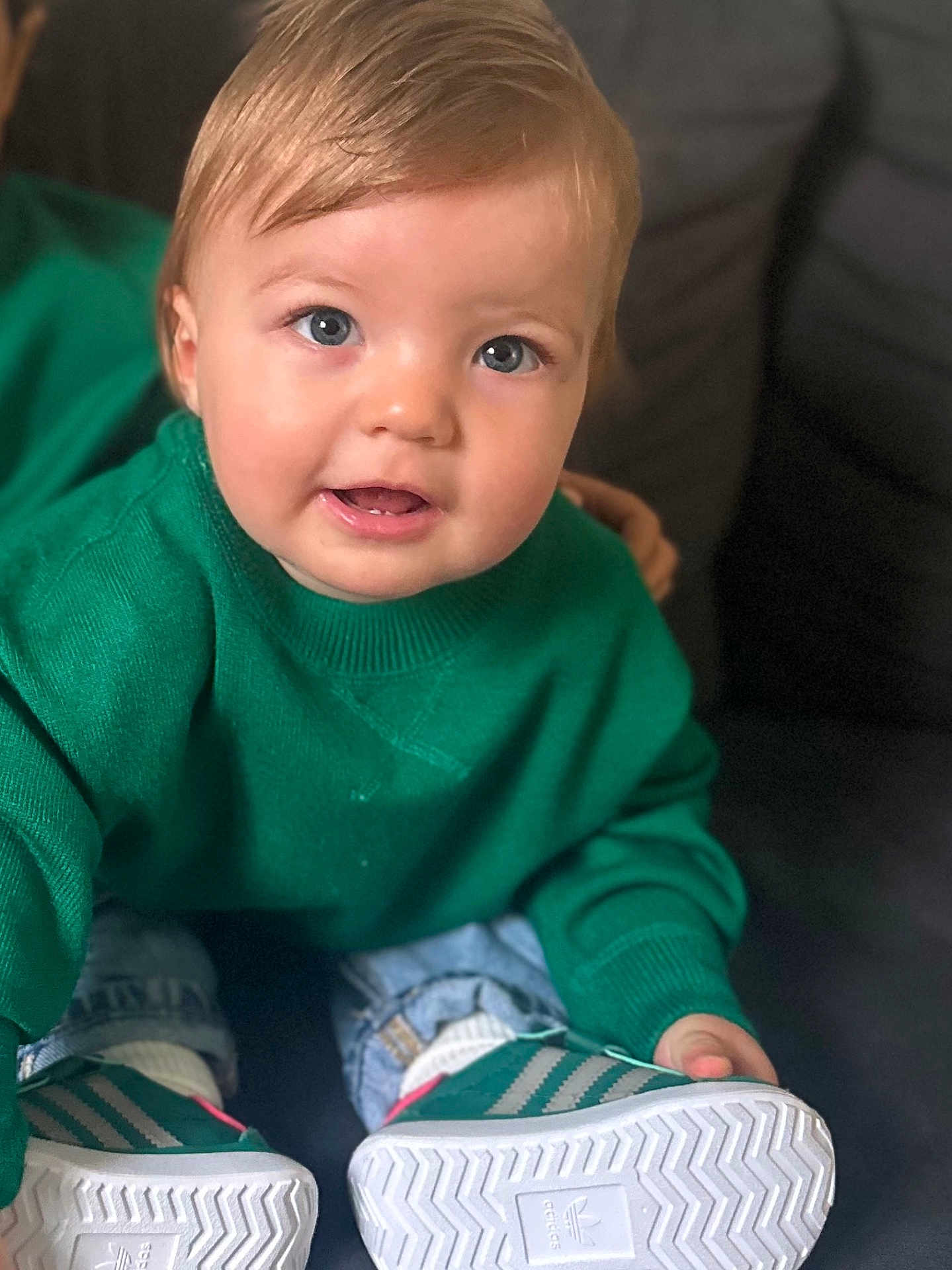 Imran participe au concours pour gagner de l'argent avec cette photo : toddler, child, green_sweater, blue_eyes, sneakers, jeans, couch, indoor, casual_clothing, portrait, cute, smiling, sitting, young_child, person, comfortable, fashion, footwear, happy, closeup