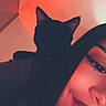 Sonic a rejoint le concours — aidez-le/la à gagner de superbes lots ! cat, black_cat, pet, animal, feline, ears, silhouette, portrait, person, face, smiling, indoor, red_lighting, ambient_lighting, bedroom, relaxed, close_up, selfie, nighttime, companion
