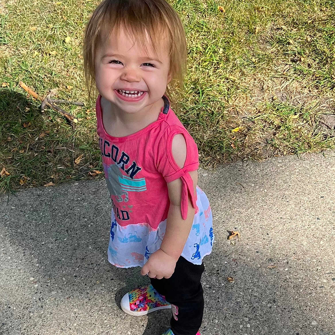 Lana joined the competition — help win amazing prizes! casual, child, colorful_clothing, cute, daylight, feet, grass, hair, happy, nature, outdoor, person, playful, portrait, rainbow_shoes, sidewalk, smiling, toddler, tree_trunk, young
