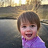 Lana is registered to the contest to win money with this photo: toddler, child, hair, static_electricity, tongue_out, smiling, sunset, backlight, outdoor, trampoline, playful, young_child, face, expression, clothing, cute, happy, nature, daylight, person