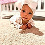 baby, carpet, child, close_up, cozy, crib, curious, cute, expression, floor, headwear, indoor, infant, nursery, person, pink_quilt, portrait, small_hands, soft_lighting, white_bow
