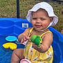 baby, blue_pool, child, cute, fun, grass, happy, outdoor, plastic_toys, playful, pool, sitting, smile, summer, sun_hat, toddler, toy, water, white_hat, yellow_swimsuit