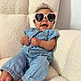 baby, barefoot, casual, child, comfortable, cozy, cute, denim_outfit, fashion, happy, headwrap, heart_shaped_sunglasses, indoor, infant, light_skin_tone, plush_chair, portrait, relaxed, sitting, smiling