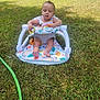 Na'Hijah is registered to the contest to win money with this photo: baby, baby_seat, grass, outdoor, child, green_hose, fence, sunlight, colorful, toy, summer, nature, person, infant, sitting, playtime, relaxing, daylight, young_child, closed_eyes