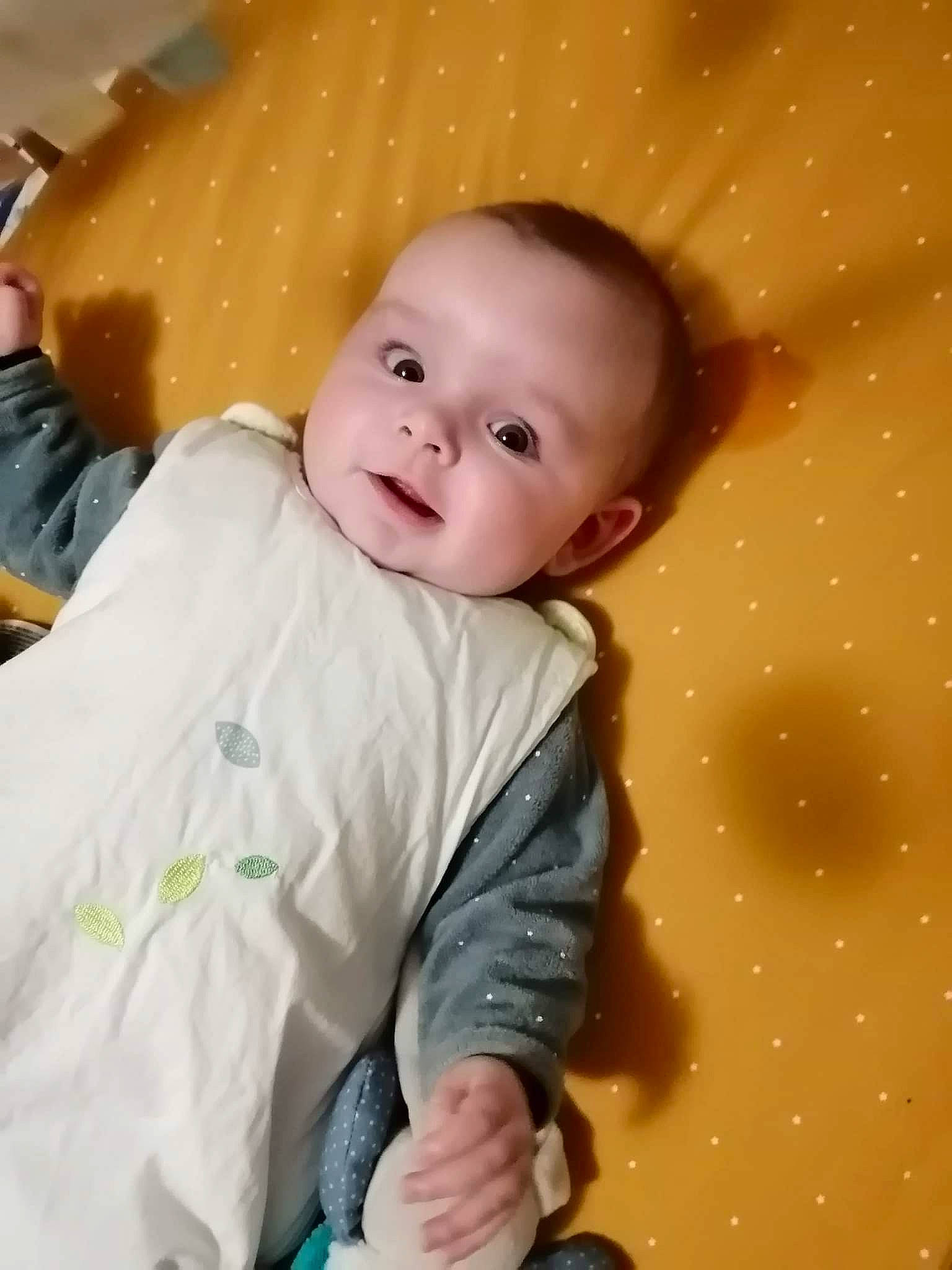 Malo participe au concours pour gagner de l'argent avec cette photo : baby, baby_products, baby_toddler_clothing, cheek, child, comfort, eye, fun, happy, head, iris, linens, nose, pattern, person, portrait_photography, sitting, skin, sleeve, smile