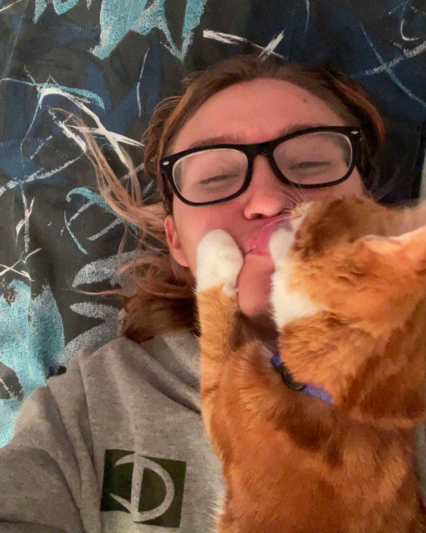 Otis is registered to the contest to win money with this photo: beard, carnivore, cat, chin, ear, eye, eyewear, felidae, finger, gesture, glasses, hair, hairstyle, head, human_body, jaw, mouth, neck, nose, vision_care