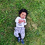 Lorenzo a rejoint le concours — aidez-le/la à gagner de superbes lots ! baby, blue_sandals, casual_clothing, child, curly_hair, cute, flowers, grass, greenery, happy, infant, lying_down, nature, outdoor, penguin_pants, playful, portrait, summer, white_shirt, young_child