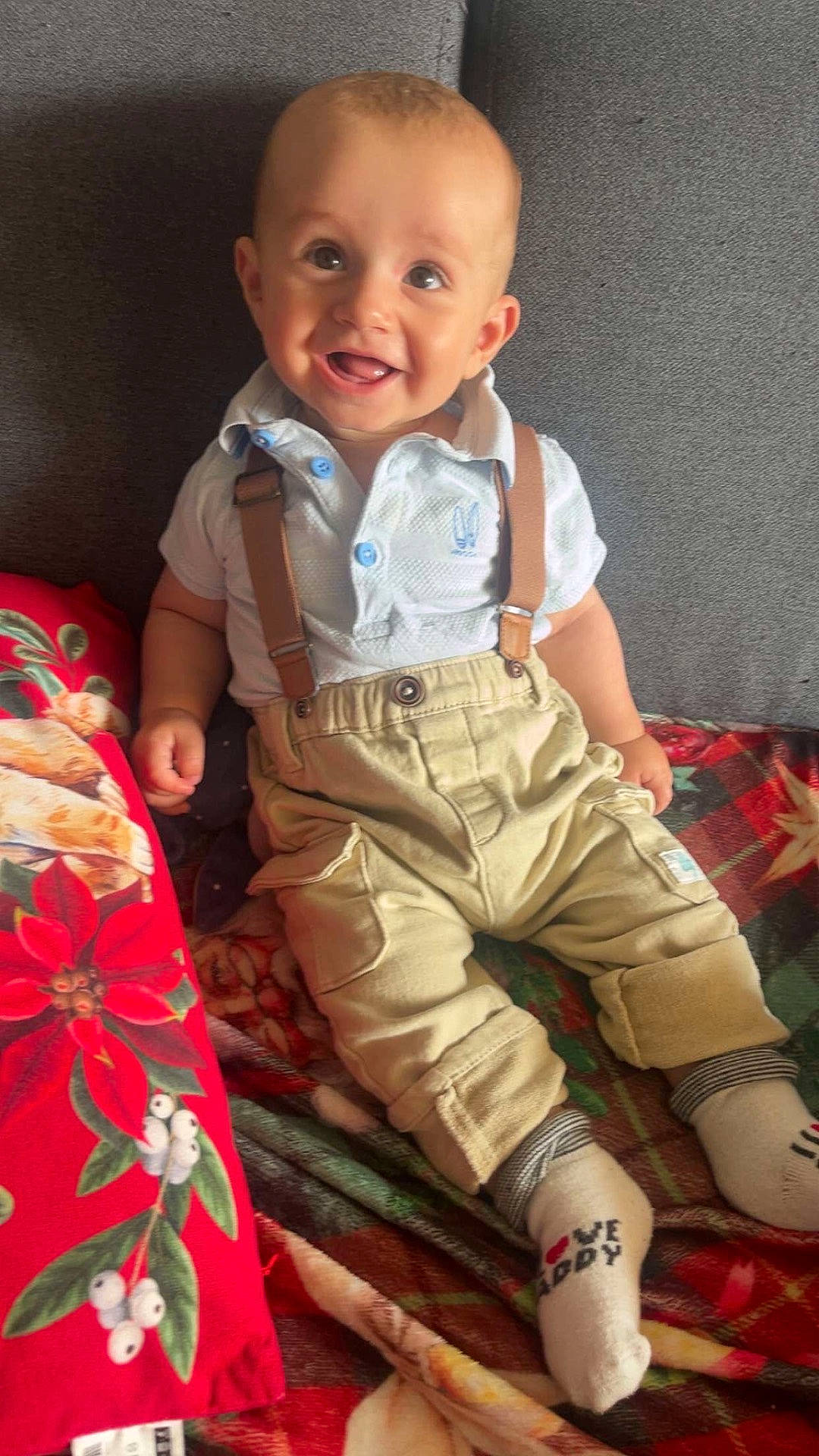 baby, blanket, child, clothing, couch, cozy, cute, face, happy, indoor, infant, pants, person, portrait, shirt, sitting, smiling, sock, suspenders, toddler