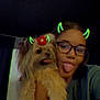Cookie joined the competition — help win amazing prizes! person, dog, pet, selfie, face, glasses, tongue_out, filter, devil_horns, flower, cute, indoor, dark_background, funny, playful, long_hair, fur, holding, smiling, young