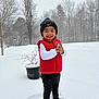 Arturo joined the competition — help win amazing prizes! child, toddler, snow, winter, red_vest, black_beanie, smile, outdoor, trees, snowflakes, footprints, potted_plant, happy, standing, cold_weather, white_snow, portrait, playful, jackets, landscape