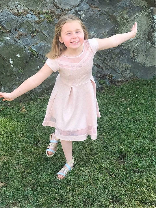 Johnna-eve is registered to the contest to win money with this photo: baby_toddler_clothing, blond, day_dress, dress, formal_wear, fun, gesture, grass, grassland, happy, human_leg, joy, meadow, one_piece_garment, pattern, people_in_nature, person, pink, plant, smile