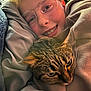 blanket, braces, cat, child, closeup, comfort, cozy, cute, face, glasses, hoodie, indoor, pet, portrait, resting, smile, snuggling, tabby_cat, warm, young