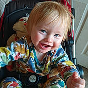 Levi joined the competition — help win amazing prizes! toddler, child, smiling, stroller, colorful_clothing, animal_print, indoor, blanket, happy, cute, baby, seatbelt, face, blue_eyes, hand, portrait, playful, cheerful, young_child, hair