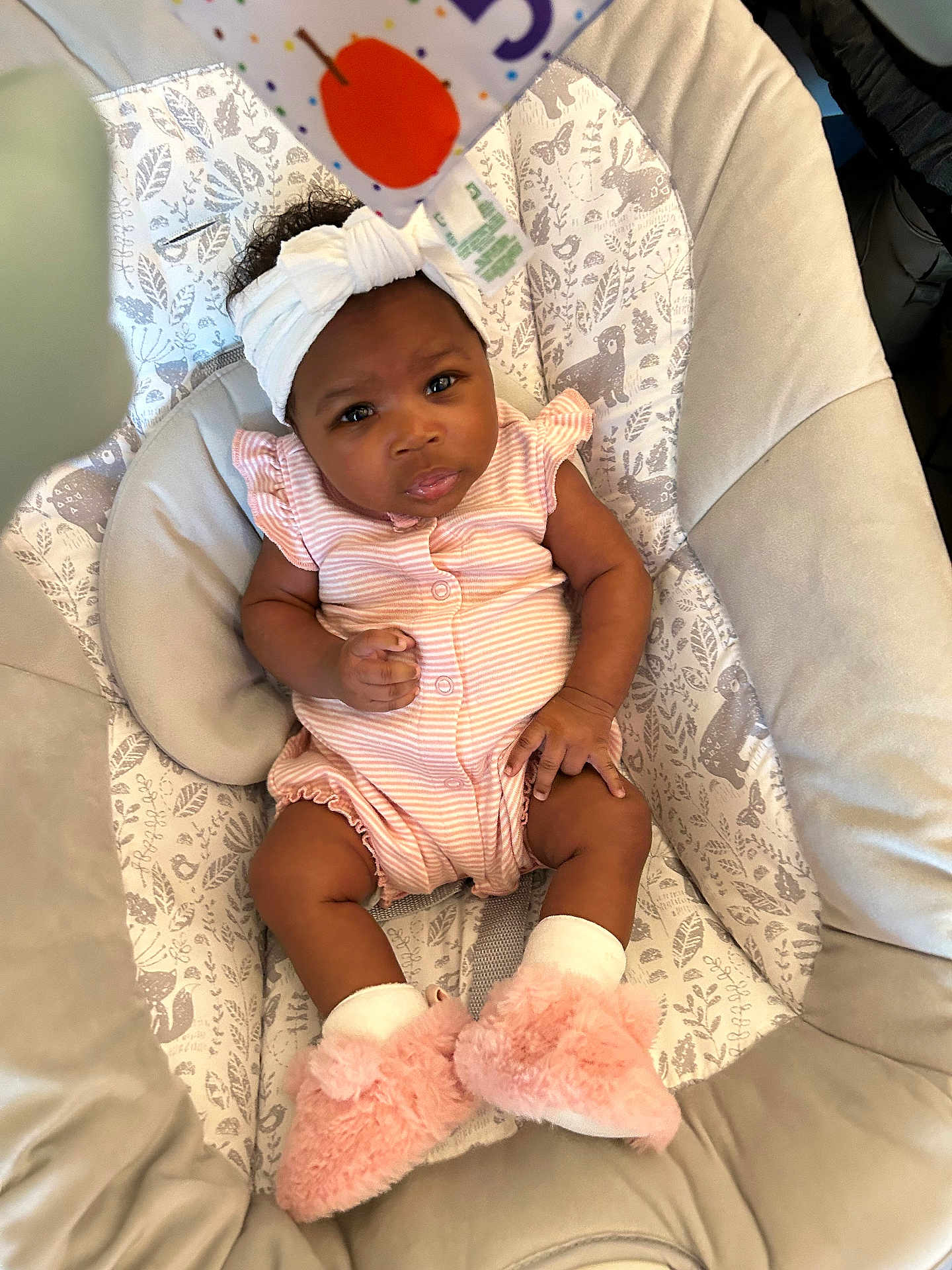 Kamora joined the competition — help win amazing prizes! baby, infant, headband, pink_clothing, booties, baby_seat, patterned_fabric, animal_print, curious_expression, indoor, soft_lighting, cute, child, cozy, toddler, smiling, person, small_hands, footwear, comfortable