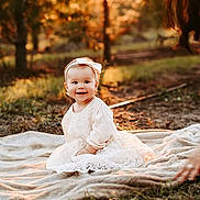 Victoria joined the competition — help win amazing prizes! adult, baby, clothing, dress, face, female, grass, happy, head, nature, outdoors, person, photography, plant, portrait, sitting, sky, smile, sunlight, woman