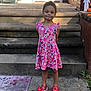 Bailey is registered to the contest to win money with this photo: brick_wall, butterfly_sandals, child, concrete, door, fall_leaves, floral_pattern, girl, outdoor, pink_dress, plant, playful, pumpkin, shadow, sidewalk, smile, standing, steps, sunlight, toy