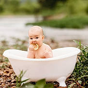 Ryleigh is registered to the contest to win money with this photo: baby, bathtub, lemon, outdoor, nature, greenery, rocks, infant, curious, sitting, cute, small_bathtub, fruit, cheeks, portrait, child, water, fresh, natural_light, playful
