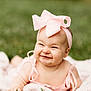 Ryleigh is registered to the contest to win money with this photo: baby, infant, smiling, pink_bow, headband, blanket, grass, outdoor, cute, portrait, happy, child, toddler, skin, face, expression, nature, daylight, clothing, lying_down