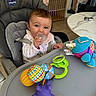 baby, high_chair, pacifier, toy, colorful, indoor, child, person, seat, table, floor, window, blanket, clothing, playtime, furniture, home, cute, smiling, infant