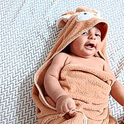 Zayn a rejoint le concours — aidez-le/la à gagner de superbes lots ! baby, towel, hood, child, infant, blanket, pattern, fabric, skin, cute, playful, wrapped, lying, hand, face, expression, soft, comfort, indoors, cozy
