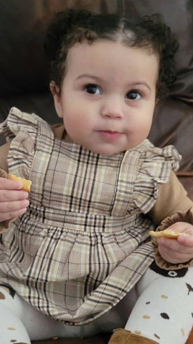 Amayah is registered to the contest to win money with this photo: baby, baby_toddler_clothing, cheek, child, dress_shirt, eye, finger, food, hair, hand, lip, nose, pattern, person, plaid, sitting, skin, sleeve, tableware, tartan