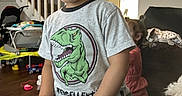 Aryan joined the competition — help win amazing prizes! carpet, child, couch, curious, dinosaur, dog, expression, floor, furniture, indoor, keyboard, living_room, music, person, plastic_cap, play, stairs, toddler, toy, tshirt
