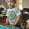 carpet, child, couch, curious, dinosaur, dog, expression, floor, furniture, indoor, keyboard, living_room, music, person, plastic_cap, play, stairs, toddler, toy, tshirt